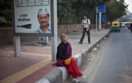 An Indian woman waits for bus as she sits near an election advertisement with a photograph of Aam Aadmi Party leader Arvind Kejriwal at a bus stop in New Delhi, India, Sunday, Feb. 8, 2015. A slew of exit polls Saturday predicted an outright victory for Aam Aadmi Party, an upstart anti-corruption party in elections to install a state government in India's capital, a potentially huge blow for Prime Minister Narendra Modi's Hindu nationalist party. Hindi reads, "five years Kejriwal".(AP)