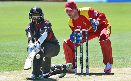 United Arab Emirates batsman Swapnil Patil (left) sweeps the ball as Zimbabwe wicketkeeper Brendan Taylor looks on during the Pool B 2015 Cricket World Cup match between the UAE and Zimbabwe in Nelson on February 19, 2015. (AFP)