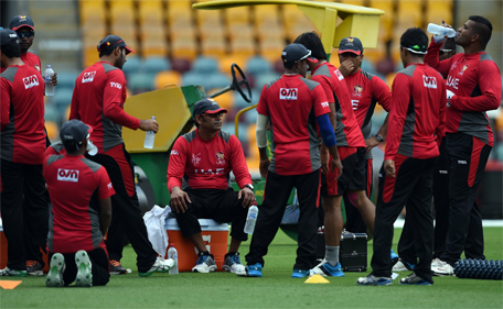 United Arab Emirates coach Aaqib Javed (5th L-seated) looks on as cricketers take a break during a training session ahead of 2015 Cricket World Cup Pool B match between Ireland and UAE at the Gabba cricket stadium in Brisbane on February 24, 2015.  (AFP)