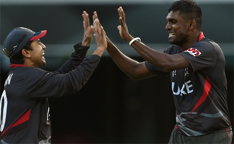 UAE's Shaiman Anwar (left) congratulates teammate Manjula Guruge after taking the wicket of unseen Ireland batsman Paul Stirling during the 2015 Cricket World Cup Pool B match between Ireland and UAE at the Gabba in Brisbane on February 25, 2015. (AFP)