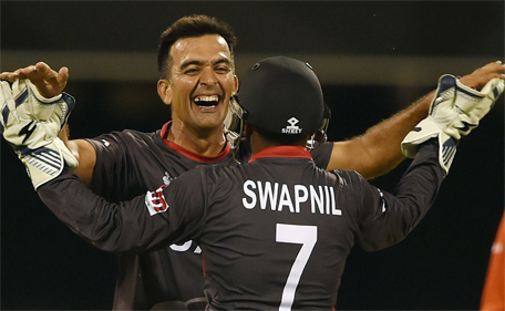 UAE capatain Mohammed Tauqir celebrates with teammate Swapnil Patil after taking the wicket of unseen Ireland batsman William Porterfield during the 2015 Cricket World Cup Pool B match between Ireland and UAE at the Gabba in Brisbane on February 25, 2015. (AFP)