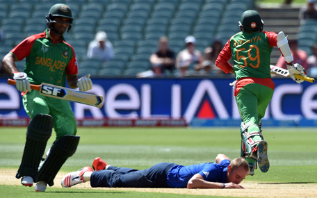 England's paceman Stuart Broad (C) falls to the ground as Bangladesh batsmen Soumya Sarkar (R) and Mahmudullah (L) run between wickets during the Pool A 2015 Cricket World Cup match between Bangladesh and England at the Adelaide Oval on March 9, 2015. (AFP)