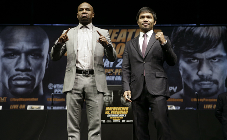 Boxers Floyd Mayweather Jr. (left) and Manny Pacquiao pose for photos after a news conference, Wednesday, March 11, 2015, in Los Angeles. (AP)