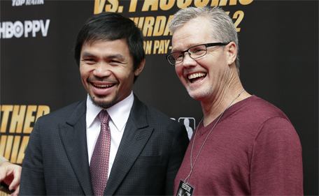 Boxer Manny Pacquiao (left) and trainer Freddie Roach pause for photos as they arrive for a news conference, Wednesday, March 11, 2015, in Los Angeles. (AP)