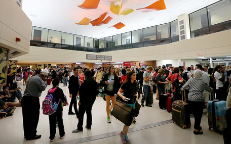Hundreds of people wait in line in the ticketing area of New Orleans International Airport after a machete-wielding man was shot by a TSA employee in Concourse B on Friday evening, March 20, 2015. (AP)