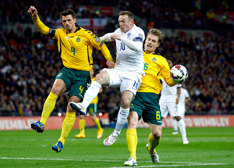 England's Wayne Rooney, center and Lithuania's Marius Zaliukas, right, and Lithuania's Tadas Kijanskas, left, challenge for the ball during the Euro 2016 Group E qualifying soccer match between England and Lithuania at Wembley Stadium in London, Friday, March 27, 2015. (AP)