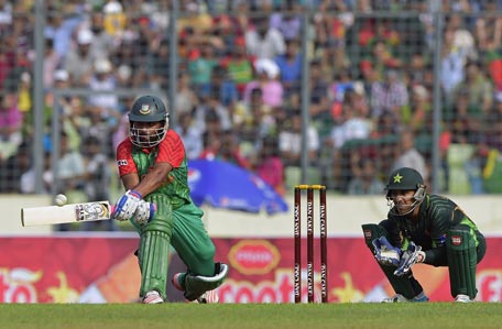Bangladesh cricketer Tamim Iqbal (L) plays a shot as Pakistan wicketkeeper Sarfraz Ahmed looks on during the first One Day International cricket match between Bangladesh and Pakistan at the Sher-e-Bangla National Cricket Stadium in Dhaka on April 17 , 2015. AFP