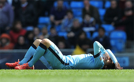 Manchester City's Spanish midfielder David Silva lies on the floor injured after taking a knock in the face in a challenge with West Ham United's Senegalese midfielder Cheikhou Kouyate during the English Premier League football match between Manchester City and West Ham United at the Etihad Stadium in Manchester, England on April 19, 2015. (AFP)