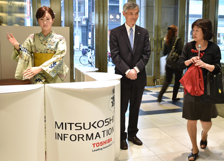 Humanoid ChihiraAico (L) clad in a Japanese kimono greets a customer at an entrance of a department store in Tokyo on April 20, 2015. She can smile, she can sing, and she can give you guidance at one of the most upscale department stores in Tokyo. Code-named ChihiraAico (like a Japanese woman's name, Aico Chihira) is a female-looking humanoid developed by Japan's Toshiba, making her debut on April 20 as a receptionist.  (AFP)