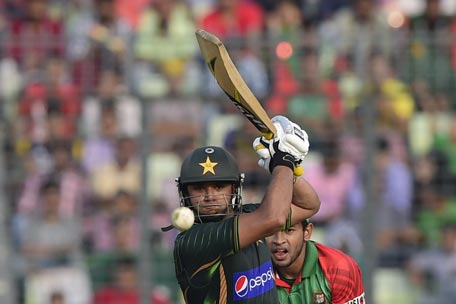 Pakistan captain Azhar Ali (L) plays a shot as Bangladesh wicketkeeper Mushfiqur Rahim (R) looks on during the third One Day International cricket match between Bangladesh and Pakistan at the Sher-e-Bangla National Cricket Stadium in Dhaka on April 22, 2015.  AFP