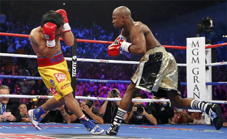Floyd Mayweather Jr of the US goes after Manny Pacquiao (left) of the Philippines in the first round during their welterweight WBO, WBC and WBA (Super) title fight in Las Vegas, Nevada, May 2, 2015. (Reuters)
