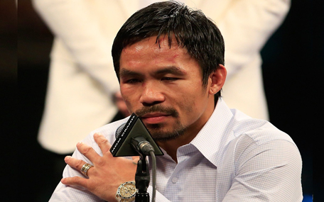 Manny Pacquiao points to his right shoulder during the post-fight news conference after losing to Floyd Mayweather Jr. in their welterweight unification championship bout on May 2, 2015 at MGM Grand Garden Arena in Las Vegas, Nevada. (Getty Images/AFP)
