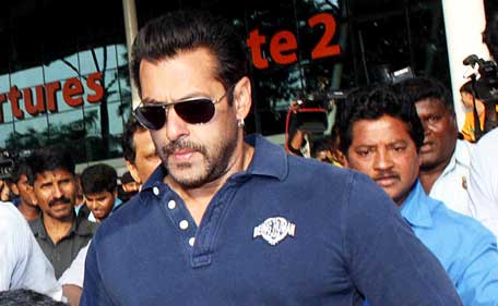 Indian Bollywood actor Salman Khan walks with officials as he arrives at an airport in Mumbai on May 5, 2015. (AFP)