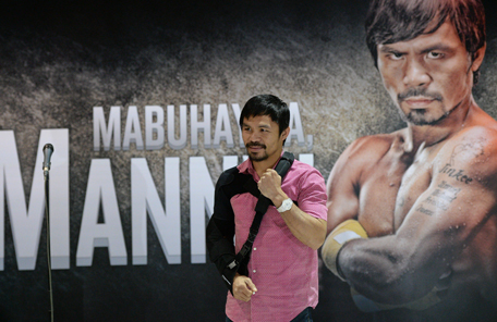 Filipino ring icon Manny Pacquiao poses for photo after a press conference shortly after arriving from the US at the international airport in Manila on May 13, 2015. (AFP)