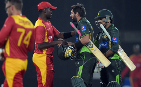 Pakistani captain Shahid Afridi (second right) and teammate Sarfraz Ahmed shakes hands with Zimbabwean captain Elton Chigumbura (second left) at the end of the first International T20 cricket match at the Gaddafi Cricket Stadium in Lahore on May 22, 2015. (AFP)