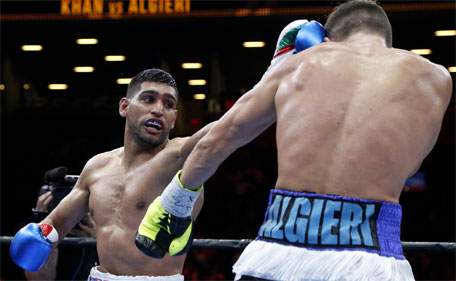Amir Khan (left) throws a left at Chris Algieri during the third round of a boxing bout Friday, May 29, 2015, in New York. (AP)