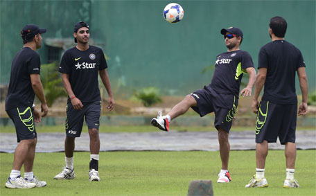 Indian cricketer Suresh Raina (second right) plays football as the captain Mahendra Singh Dhoni (left) looks on during a practice session at the Sher-e-Bangla National Cricket Stadium in Dhaka on June 17, 2015, ahead of the first ODI cricket match against Bangladesh. (AFP)