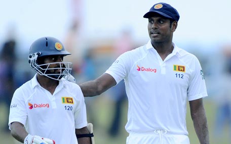 Sri Lanka cricket team captain Angelo Mathews (R) and Kaushal Silva leave the pitch at the end of the second day of the opening Test cricket match between Sri Lanka and Pakistan at the Galle International Cricket Stadium in Galle on June 18, 2015. AFP