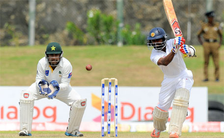 Sri Lankan batsman Kaushal Silva (right) plays a shot as Pakistan wicketkeeper Sarfraz Ahmed looks on during the third day of the opening Test match between Sri Lanka and Pakistan at the Galle International Cricket Stadium in Galle on June 19, 2015. (AFP)