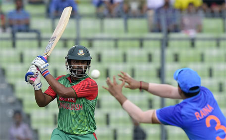 Bangladesh batsman Tamim Iqbal (left) plays a shot as Indian cricketer Suresh Raina tries to catch the ball during the first one day international cricket match between Bangladesh and India at The Sher-e-Bangla National Cricket Stadium in Dhaka on June 18, 2015. (AFP)