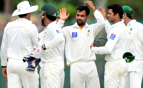 Pakistan bowler Mohammad Hafeez  (centre) celebrates the wicket of Sri Lanka's Dhammika Prasad during the second day of the 2nd Test at P Sara Oval in Colombo on June 26, 2015. (AFP)
