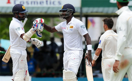 Sri Lankan cricket captain Angelo Mathews (centre) and teammate Lahiru Thirimanne (left) celebrate after victory in their second Test cricket match between Sri Lanka and Pakistan at the P. Sara Oval Cricket Stadium in Colombo on June 29, 2015. (AFP)