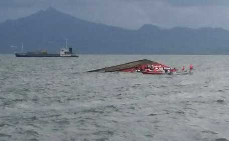 Rescuers search for survivors next to the capsized passenger ferry off Ormoc City, central Philippines on July 2, 2015. At least 36 people were killed after a passenger ferry with close to 200 people on board capsized in rough waters in the central Philippines on July 2, officials said. (AFP)