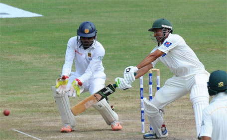 Pakistan batsman Younis Khan (centre) plays a shot as Sri Lankan wicketkeeper Dinesh Chandimal looks on during the fourth day of the third and final Test cricket match between Sri Lanka and Pakistan at the Pallekele International Cricket Stadium in Pallekele on July 6, 2015. (AFP)