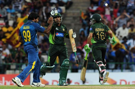 Sri Lankan cricketer Lasith Malinga (L) celebrates after dismissing Pakistan cricketer Sarfraz Ahmed (C) during the second One Day International (ODI) match between Sri Lanka and Pakistan at the Pallekele International Cricket Stadium in Pallekele on July 15, 2015. AFP
