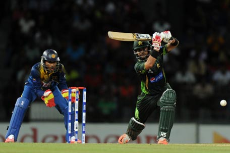 Pakistan cricketer Ahmed Shehzad (R) is watched by Sri Lankan wicketkeeper Dinesh Chandimal (L) as he plays a shot during the fourth One Day International (ODI) cricket match between Sri Lanka and Pakistan at the R Premadasa International Cricket Stadium in Colombo on July 22, 2015. AFP