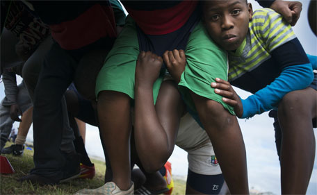 Young boys practice scrumming on a rugby field in Khayelitsha, an impoverished area about 30Km from the centre of Cape Town, on June 25, 2015. (AFP)