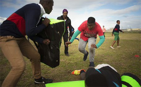 A young boy practices tackling on a rugby field in Khayelitsha, an impoverished area about 30Km from the centre of Cape Town, on June 25, 2015. (AFP)