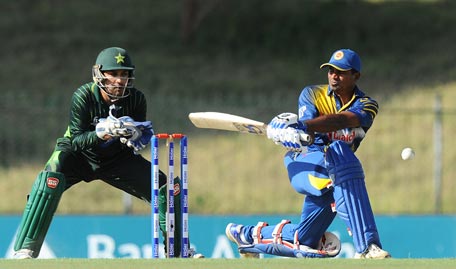 Sri Lankan cricketer Kusal Perera (R) is watched by Pakistani wicketkeeper Sarfraz Ahmed (L) as he plays a shot during the fifth and final one day international (ODI) cricket match between Sri Lanka and Pakistan at the Suriyawewa Mahinda Rajapakse International Cricket Stadium in the southern district of Hambantota on July 26, 2015. AFP