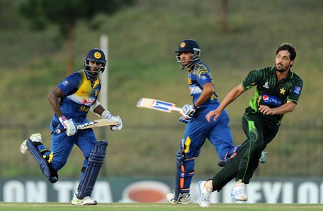 Sri Lankan cricket captain Angelo Mathews (L) and Milinda Siriwardana (C) run between the wickets as Pakistan cricketer Anwar Ali looks on during the fifth and final one day international (ODI) cricket match between Sri Lanka and Pakistan at the Suriyawewa Mahinda Rajapakse International Cricket Stadium in the southern district of Hambantota on July 26, 2015. AFP