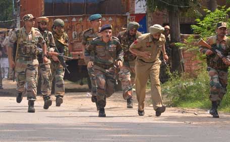Indian Army personnel run during an encounter with armed attackers at the police station in Dinanagar town, in the Gurdaspur district of Punjab state on July 27, 2015. Indian security forces were  battling an armed attack on a police station near the Pakistan border in which at least five people have been killed. (AFP)