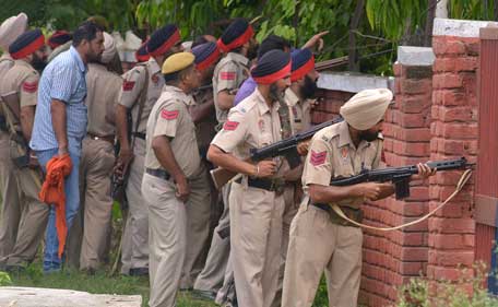 Indian Punjab police personnel take position during an encounter with armed attackers at the police station in Dinanagar town, in the Gurdaspur district of Punjab state on July 27, 2015. (AFP)
