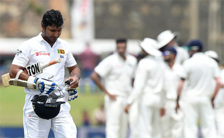 Sri Lankan cricketer Kumar Sangakkara (left) walks to the pavilion after his dismissal during the first day of the opening Test cricket match between Sri Lanka and India at The Galle International Cricket Stadium in Galle on August 12, 2015. (AFP)