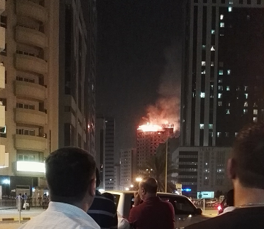 Residents watch the building on fire near Jamal Abdul Nasir Street.