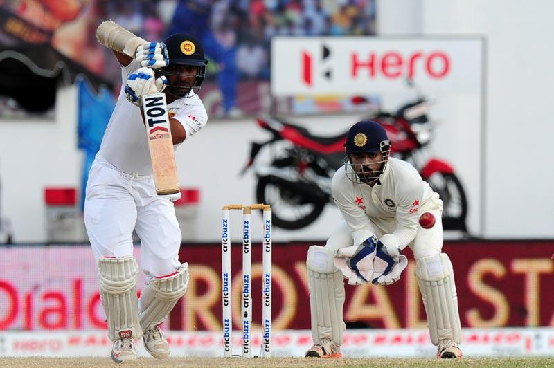 Sri Lankan cricketer Kumar Sangakkara (left) plays a shot as wicketkeeper Lokesh Rahul looks on during the fourth day of their second Test cricket match between Sri Lanka and India at the P. Sara Oval Cricket Stadium in Colombo on August 23, 2015. (AFP)