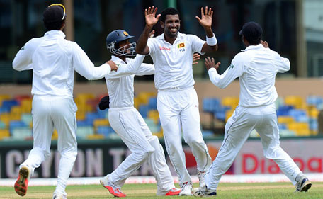 Sri Lankan cricketer Dhammika Prasad (second right) celebrates with teammates after he dismissed Indian cricketer Lokesh Rahul during the opening day of their third and final Test cricket match between Sri Lanka and India at the Sinhalese sports club (SSC) Ground in Colombo on August 28, 2015. (AFP)