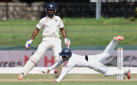 Sri Lankan cricketer Kaushal Silva drops a catch off Indian cricketer Cheteshwar Pujara (L) looks on during the second day of their third and final Test cricket match between Sri Lanka and India at the Sinhalese Sports Club (SSC) in Colombo on August 29, 2015.  (AFP)