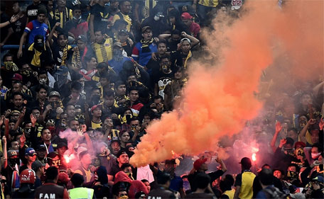 Malaysian football fans burn flares in the stands during the 2018 FIFA World Cup qualifying football match between Malaysia and Saudi Arabia in Shah Alam on September 8, 2015. (AFP)