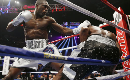 Andre Berto (left) punches Floyd Mayweather Jr. during their welterweight title boxing bout Saturday, Sept. 12, 2015, in Las Vegas. (AP)