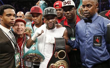 Floyd Mayweather Jr. (centre), stands with referee Kenny Bayless (right) after defeating Andre Berto during their welterweight title boxing bout Saturday, Sept. 12, 2015, in Las Vegas. (AP)