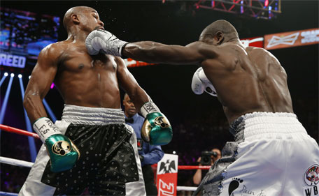 Andre Berto (right) hits Floyd Mayweather Jr. during their welterweight title boxing bout Saturday, Sept. 12, 2015, in Las Vegas. (AP)