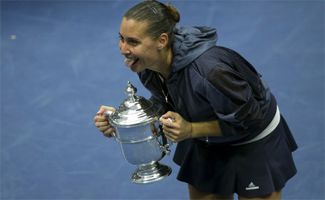 Flavia Pennetta of Italy sticks out her tongue as she holds the champion's trophy after winning the women's singles final match against compatriot Roberta Vinci at the U.S. Open Championships tennis tournament in New York, September 12, 2015. (Reuters)