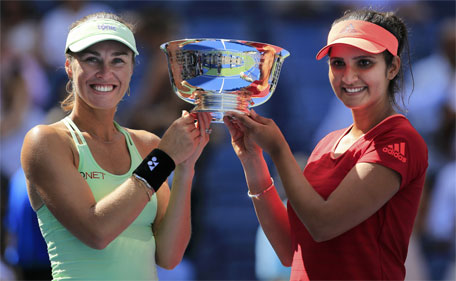 Martina Hingis (left) of Switzerland and Sania Mirza of India hold their trophy after defeating Casey Dellacqua of Australia and Yaroslava Shvedova of Kazakhstan in their women's doubles finals match at the U.S. Open Championships tennis tournament in New York, September 13, 2015. (Reuters)