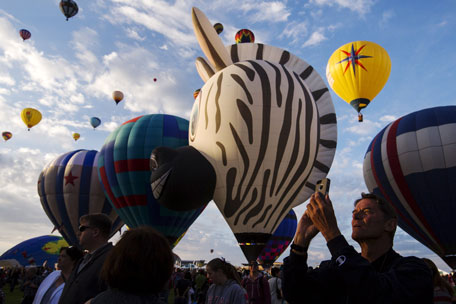 A man uses his phone to take pictures as hundreds of hot air balloons lift off on the first day of the 2015 Albuquerque International Balloon Fiesta in Albuquerque, New Mexico, October 3, 2015.  (Reuters)