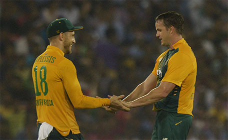 South Africa's captain Faf du Plessis (left) congratulates Albie Morkel for taking the wicket of India's Bhuvneshwar Kumar during the second T20 cricket match between India and South Africa at The Barabati Stadium in Cuttack on October 5, 2015. (AFP)