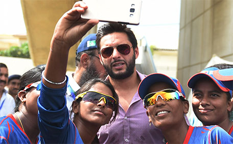 Bangladeshi women cricketers take a selfie with Pakistani cricketer Shahid Afridi (centre) in Karachi on October 5, 2015. (AFP)
